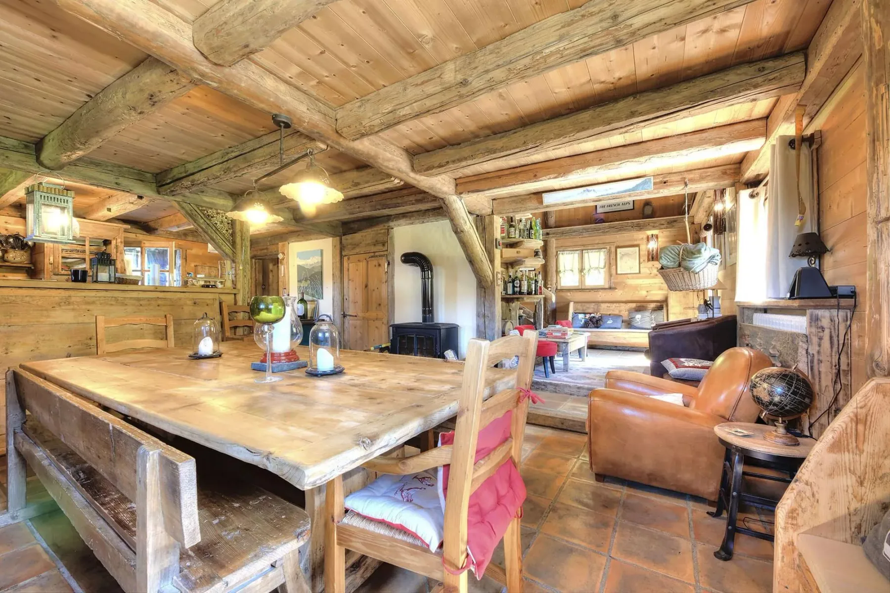 Rustic wood-paneled living and dining area with a large table and seating.