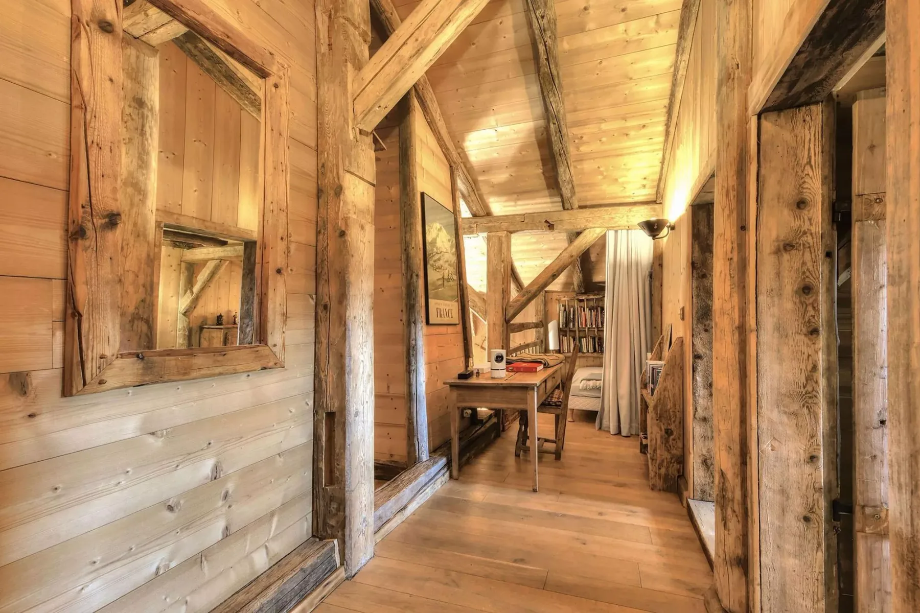 A timber hallway with a small table and a curtained opening.