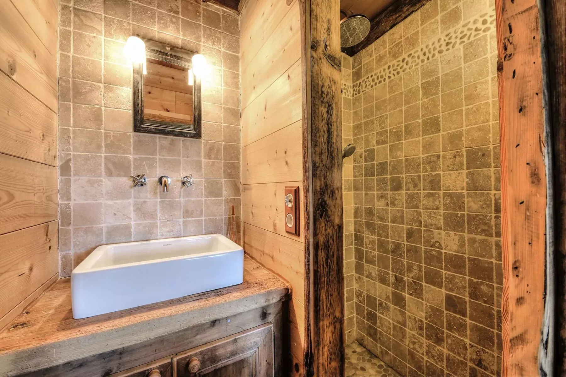 Rustic bathroom with a bathtub and tiled shower area.
