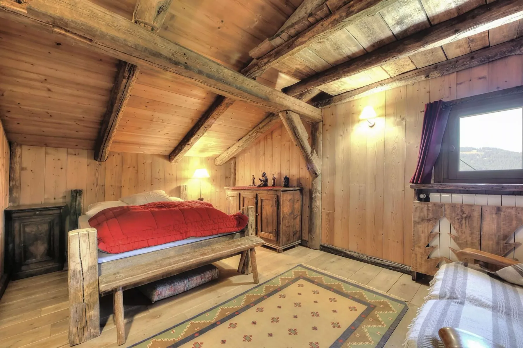 A wood-paneled bedroom with a bed and a window.