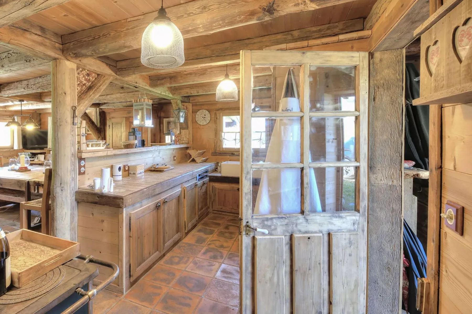 A rustic kitchen with wooden counters and a glass-paneled partition.
