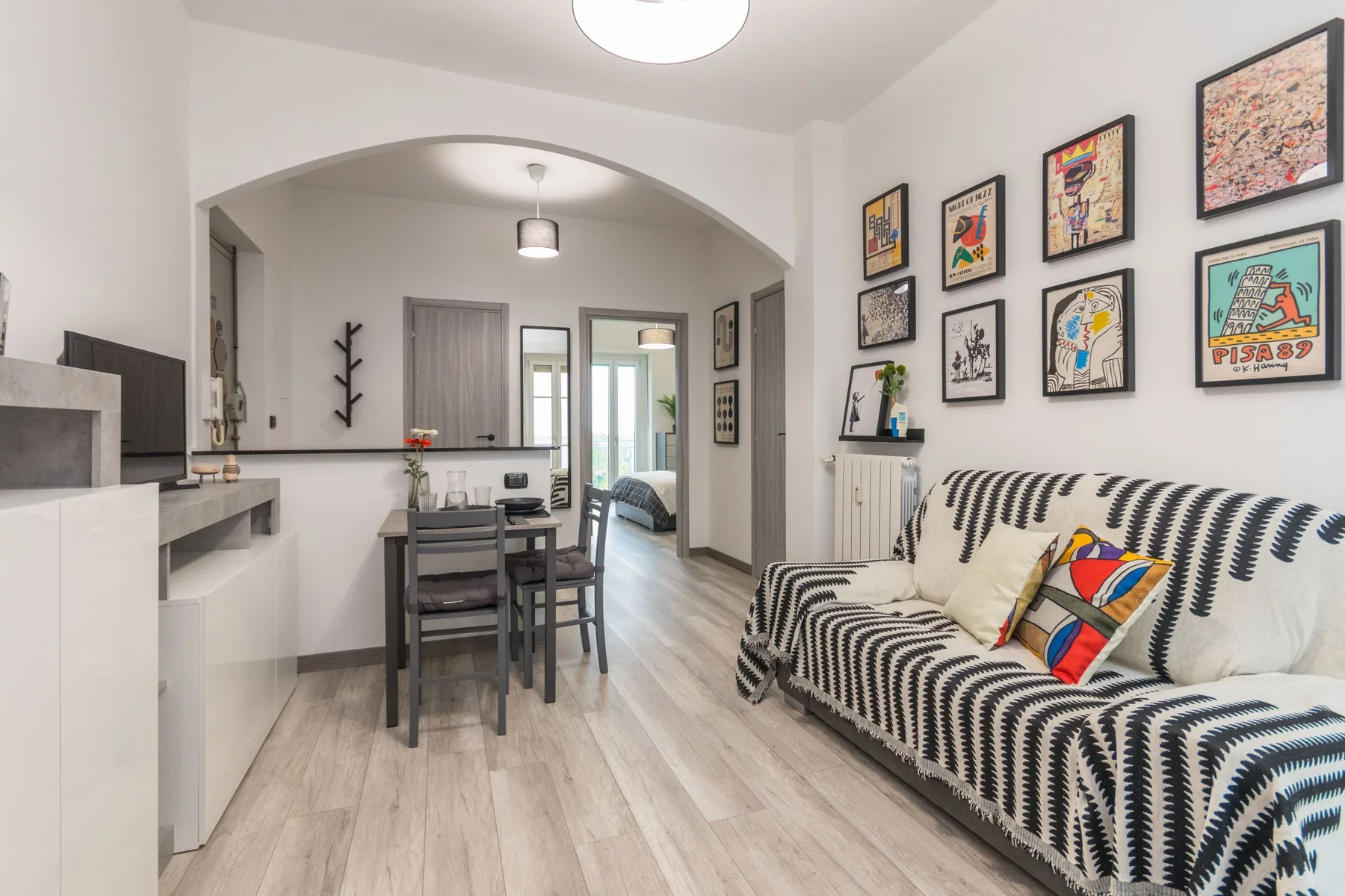 Una sala luminosa con asientos estampados, cuadros enmarcados y un comedor.