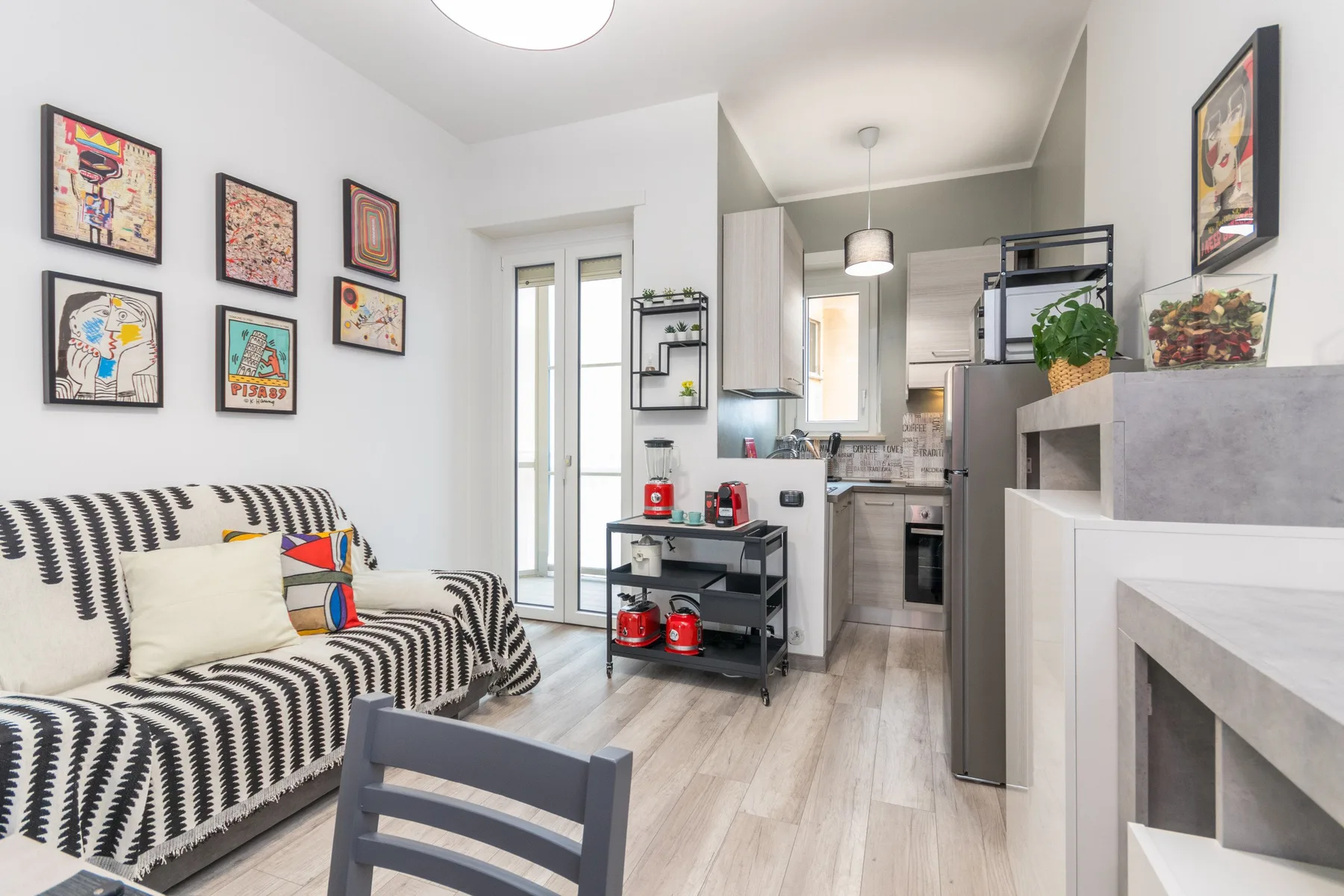 Una sala de estar con asientos estampados se abre a una cocina compacta.