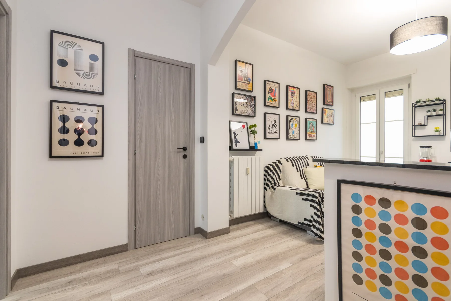 Una habitación luminosa con cuadros enmarcados y una zona de asientos.