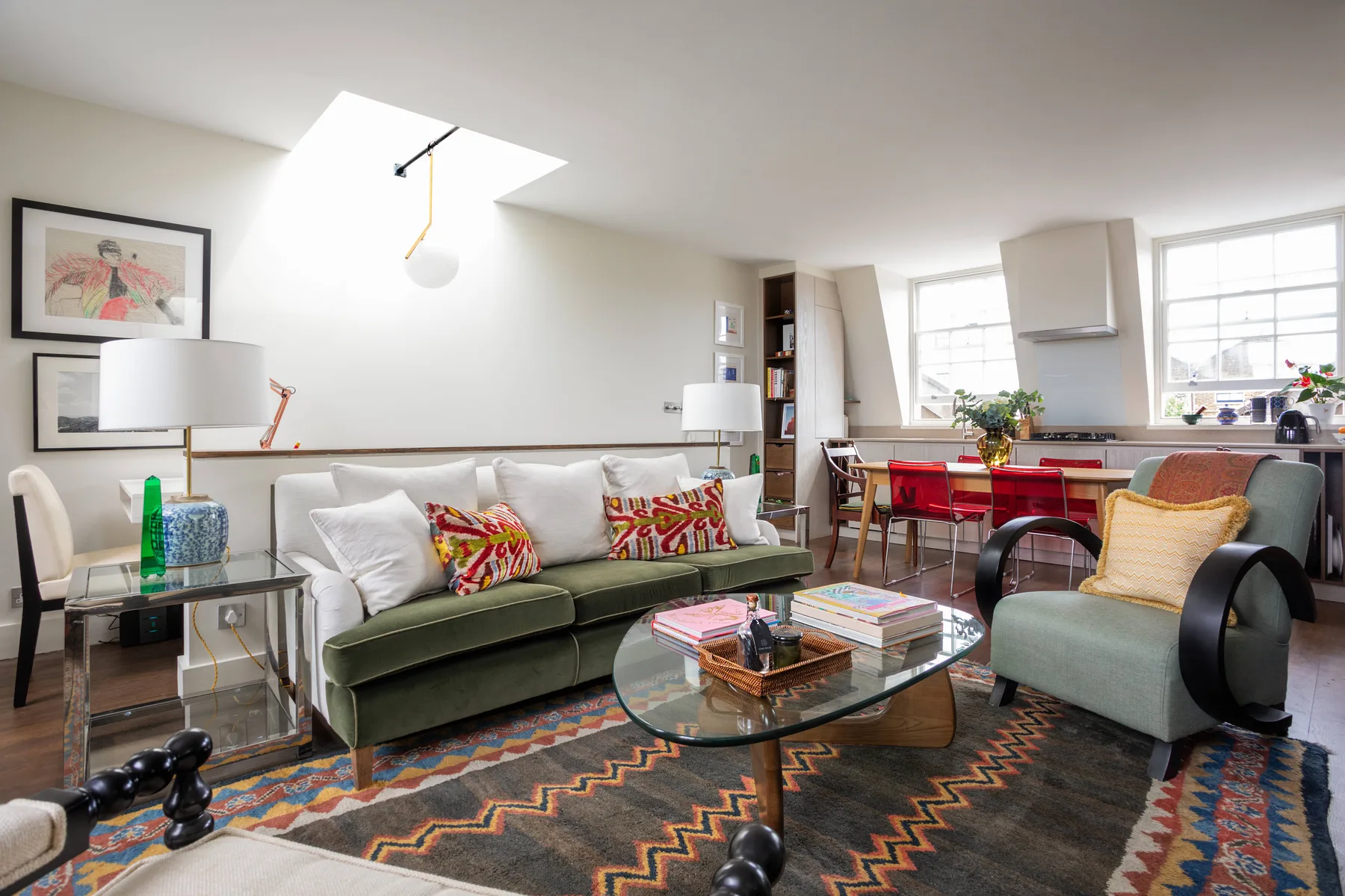 A bright living room with a green sofa and a glass coffee table.