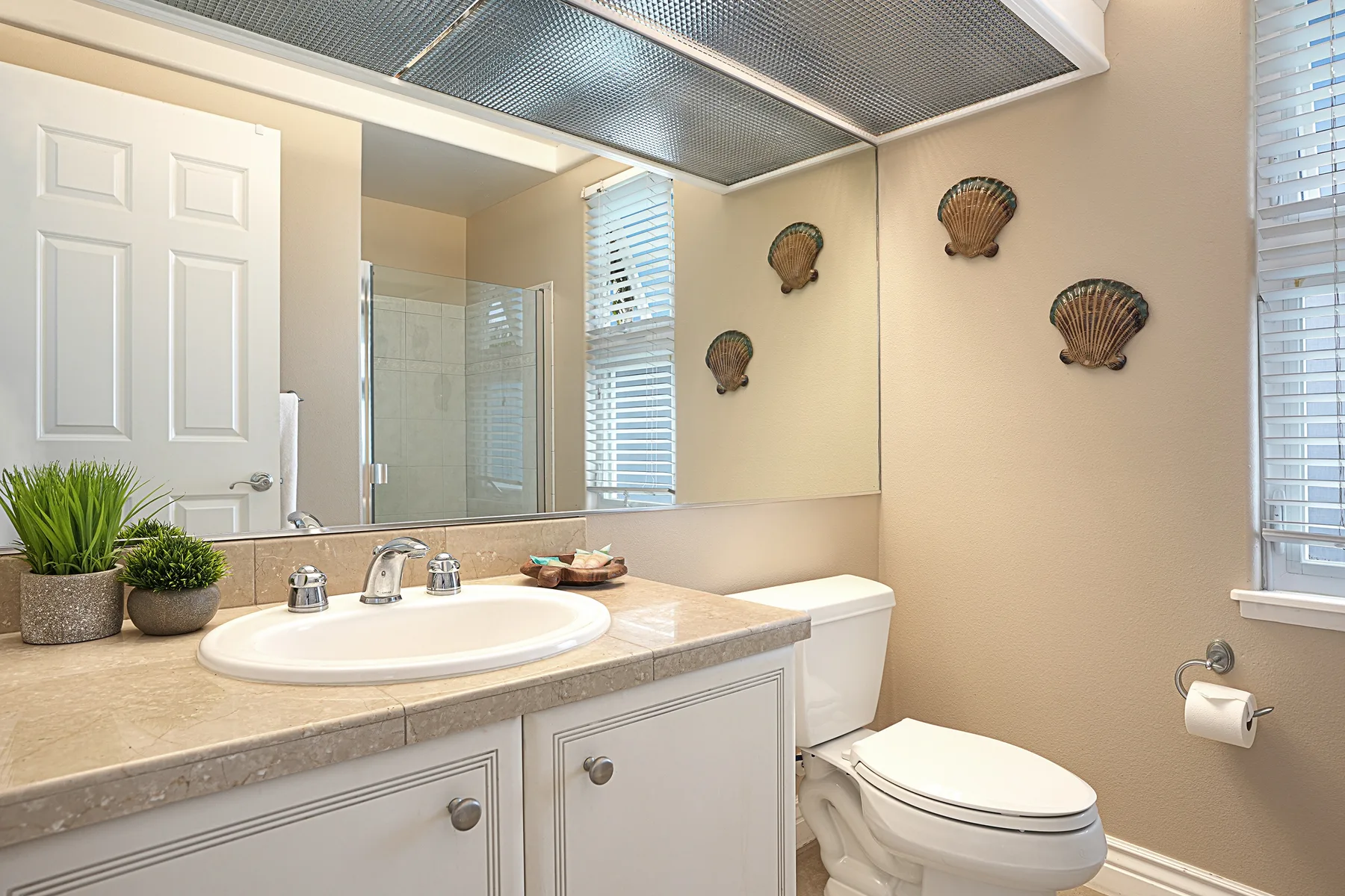 A bathroom with a sink, mirror, and toilet.