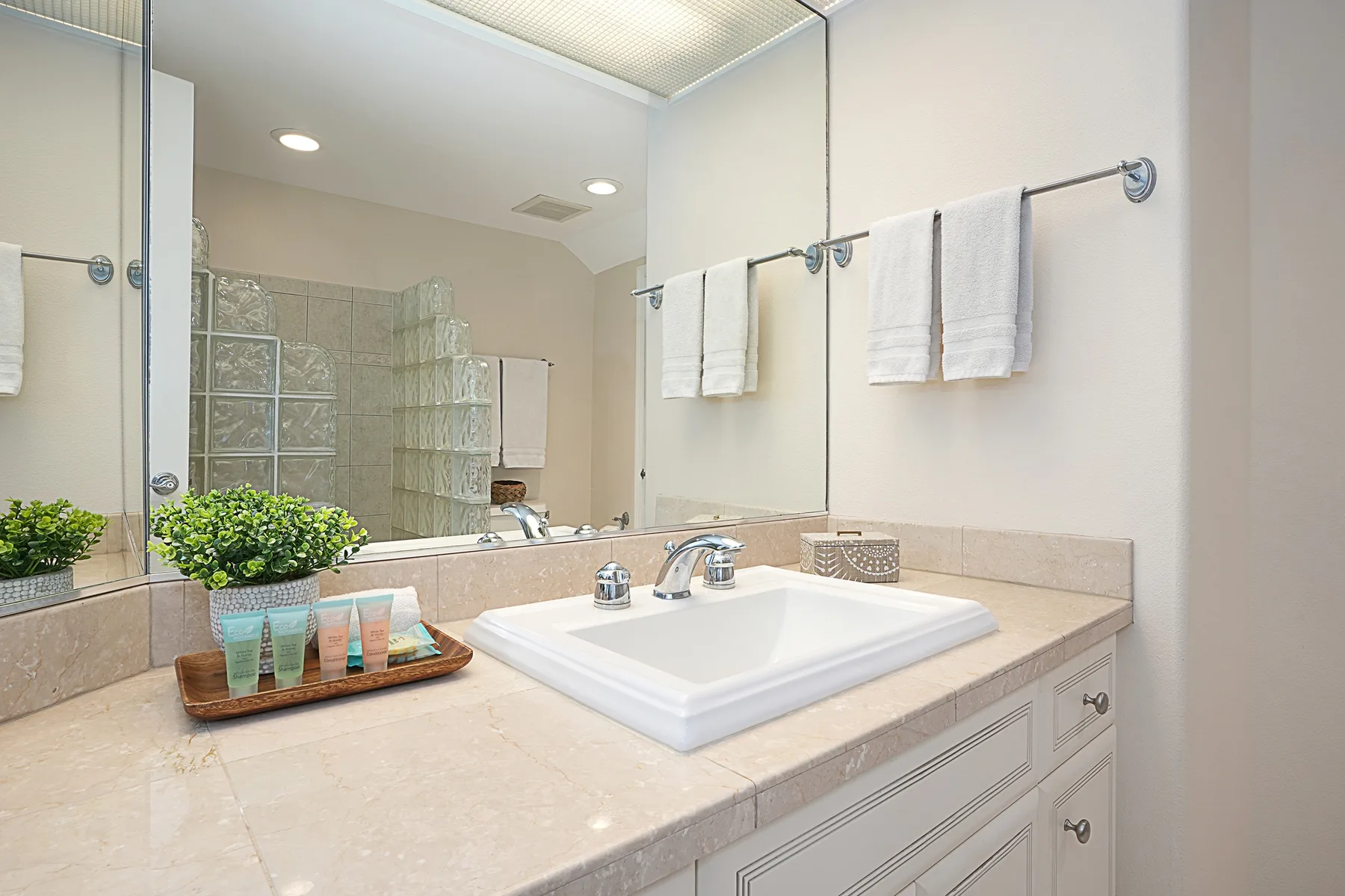 A bathroom vanity with a sink, mirror, and folded towels.