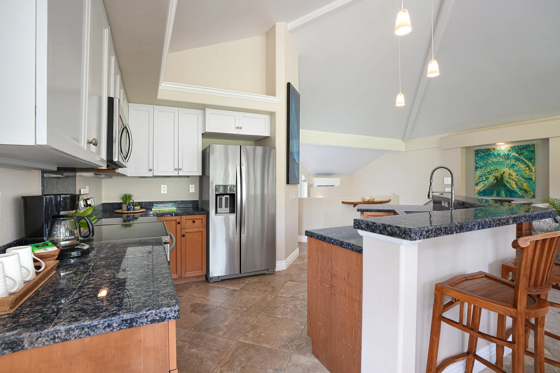 A spacious kitchen with dark countertops, stainless steel appliances, and a central island.