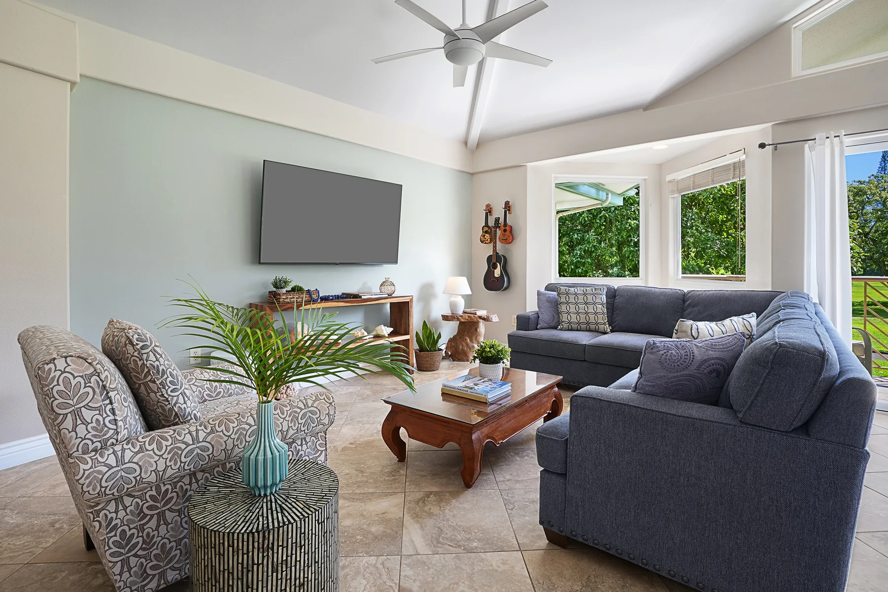 A bright living room with seating arranged around a coffee table and television.