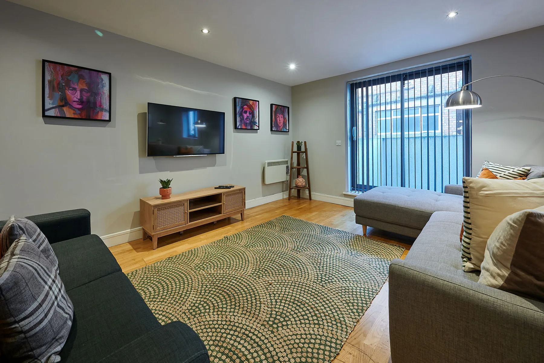 Una sala de estar con asientos, un televisor y una alfombra estampada.