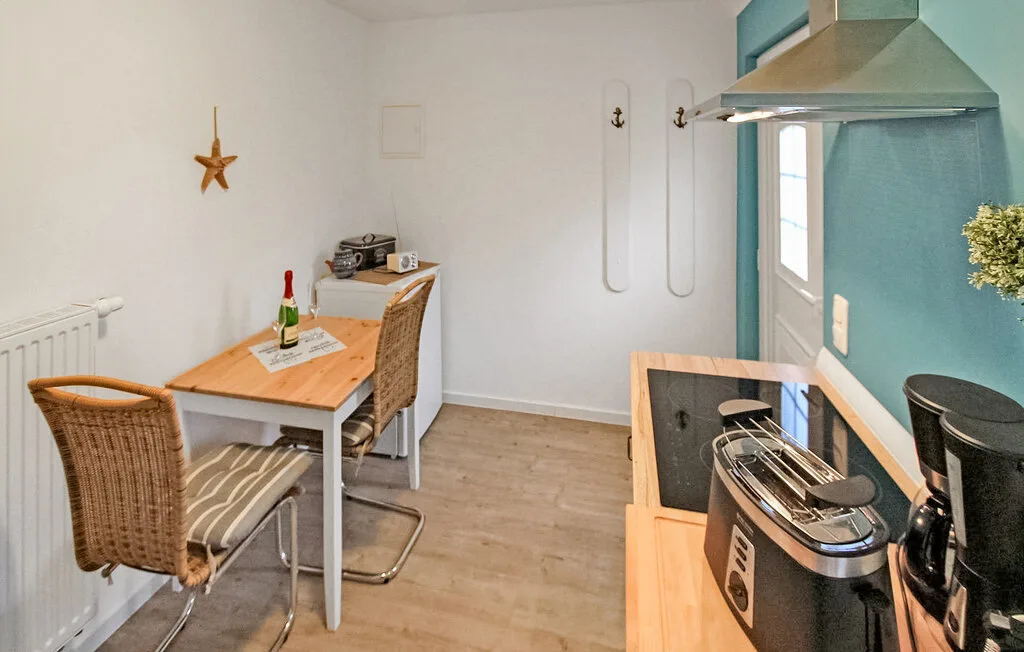 Una cocina compacta y zona de comedor con una mesa junto a la encimera.