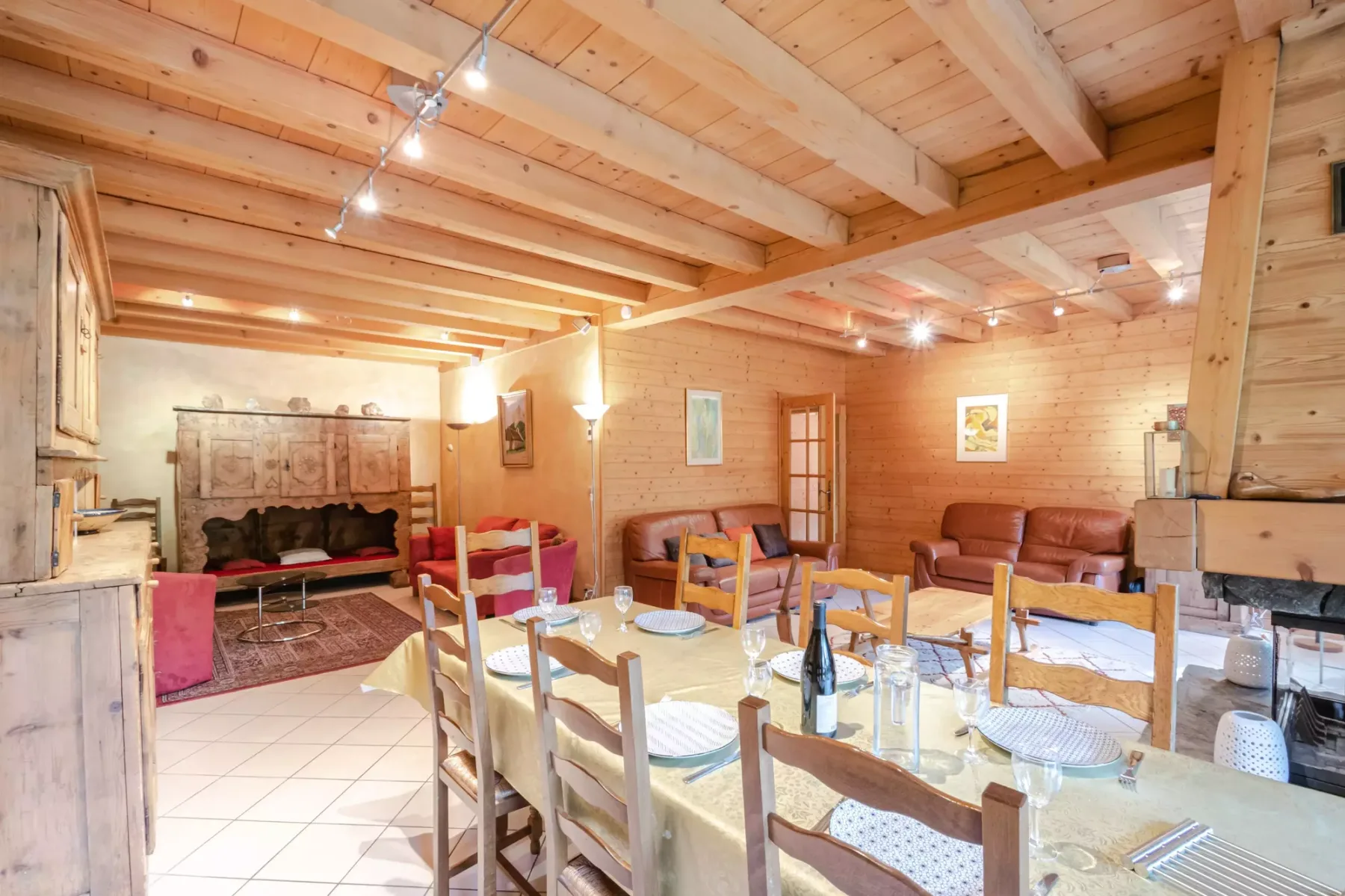 A wood-paneled dining room with a long table and seating beside a lounge area.