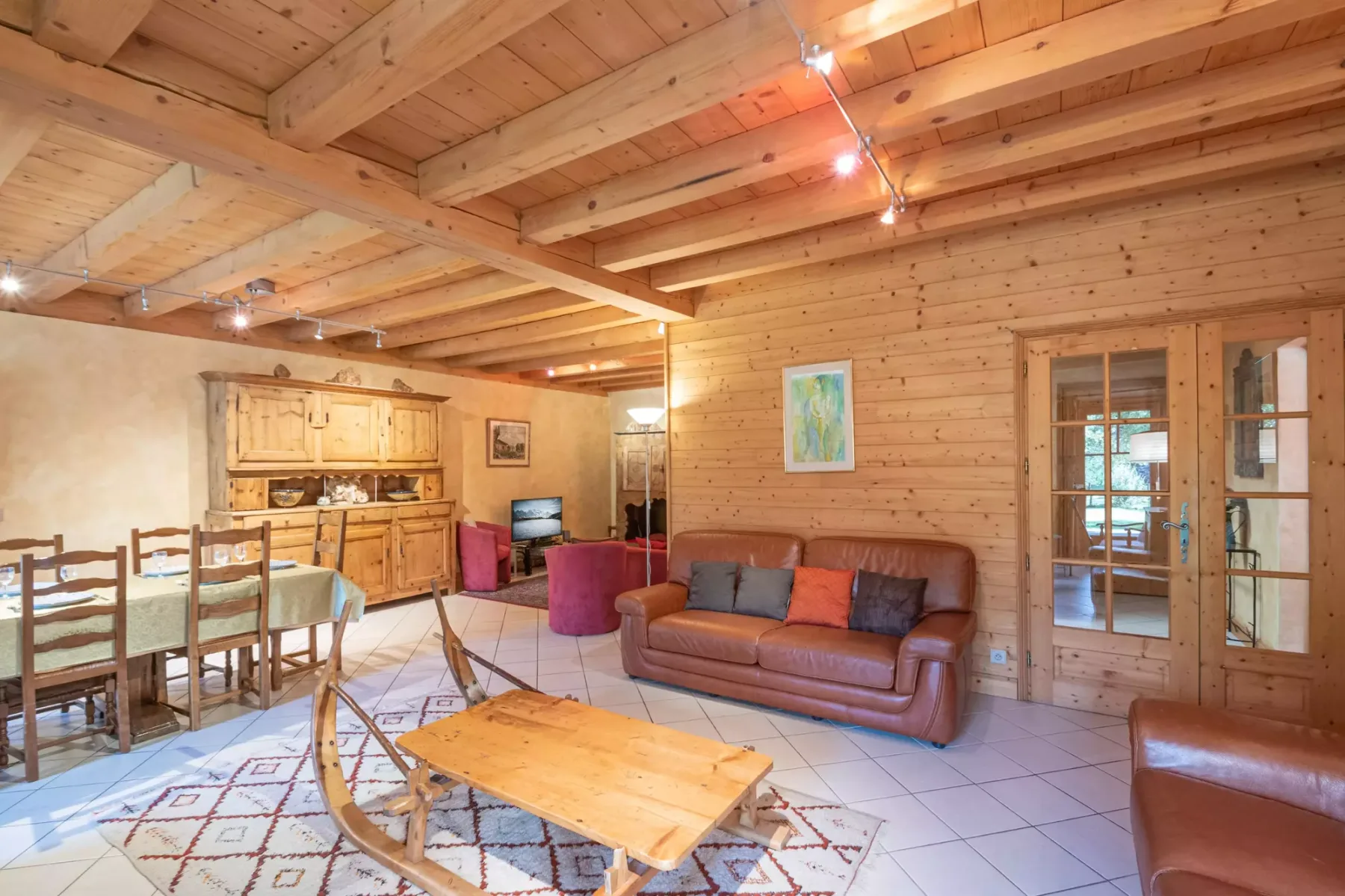 A wood-paneled living and dining area with a sofa and dining table.