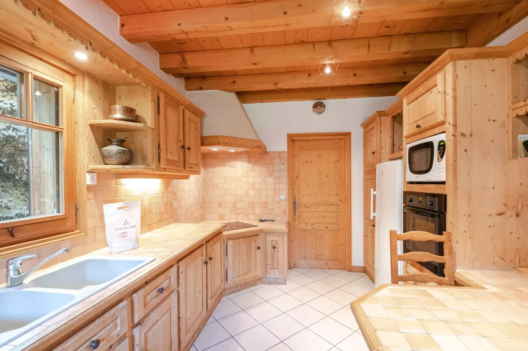 A wood-paneled kitchen with counters, a sink, and built-in appliances.