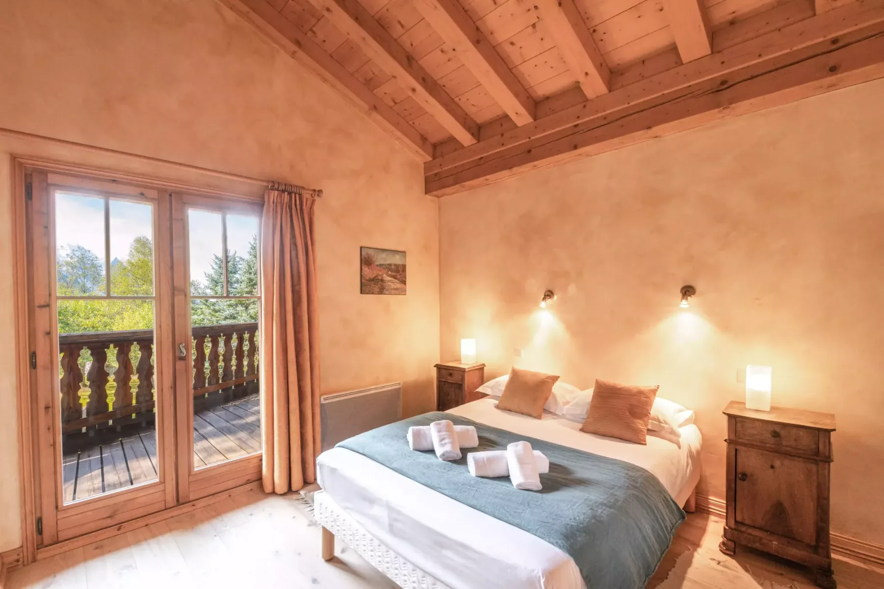A bedroom with a bed beside glass doors opening onto a balcony.