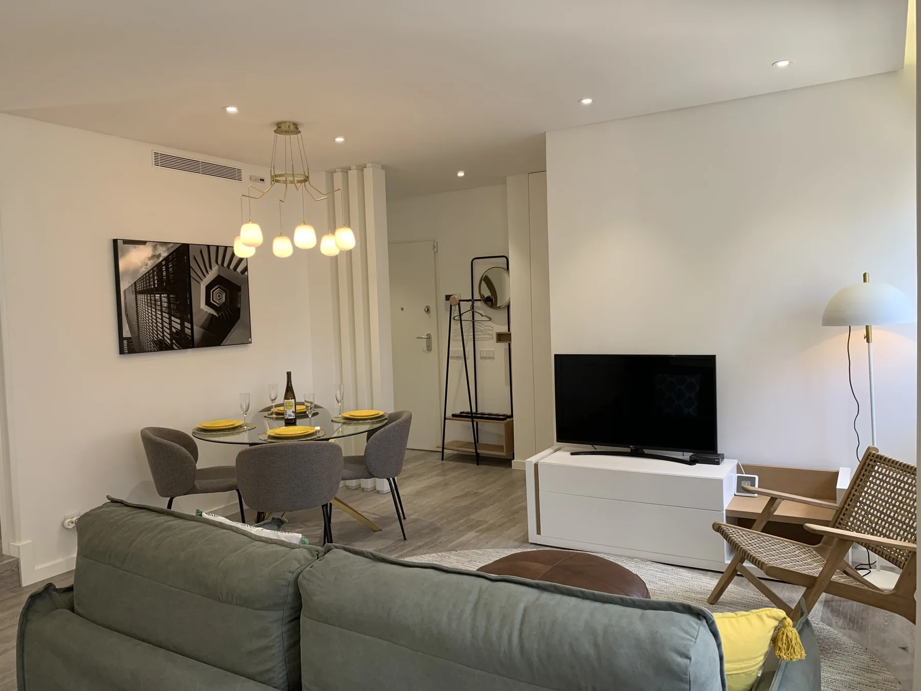 Una sala de estar y comedor con asientos, un televisor y una mesa de comedor.
