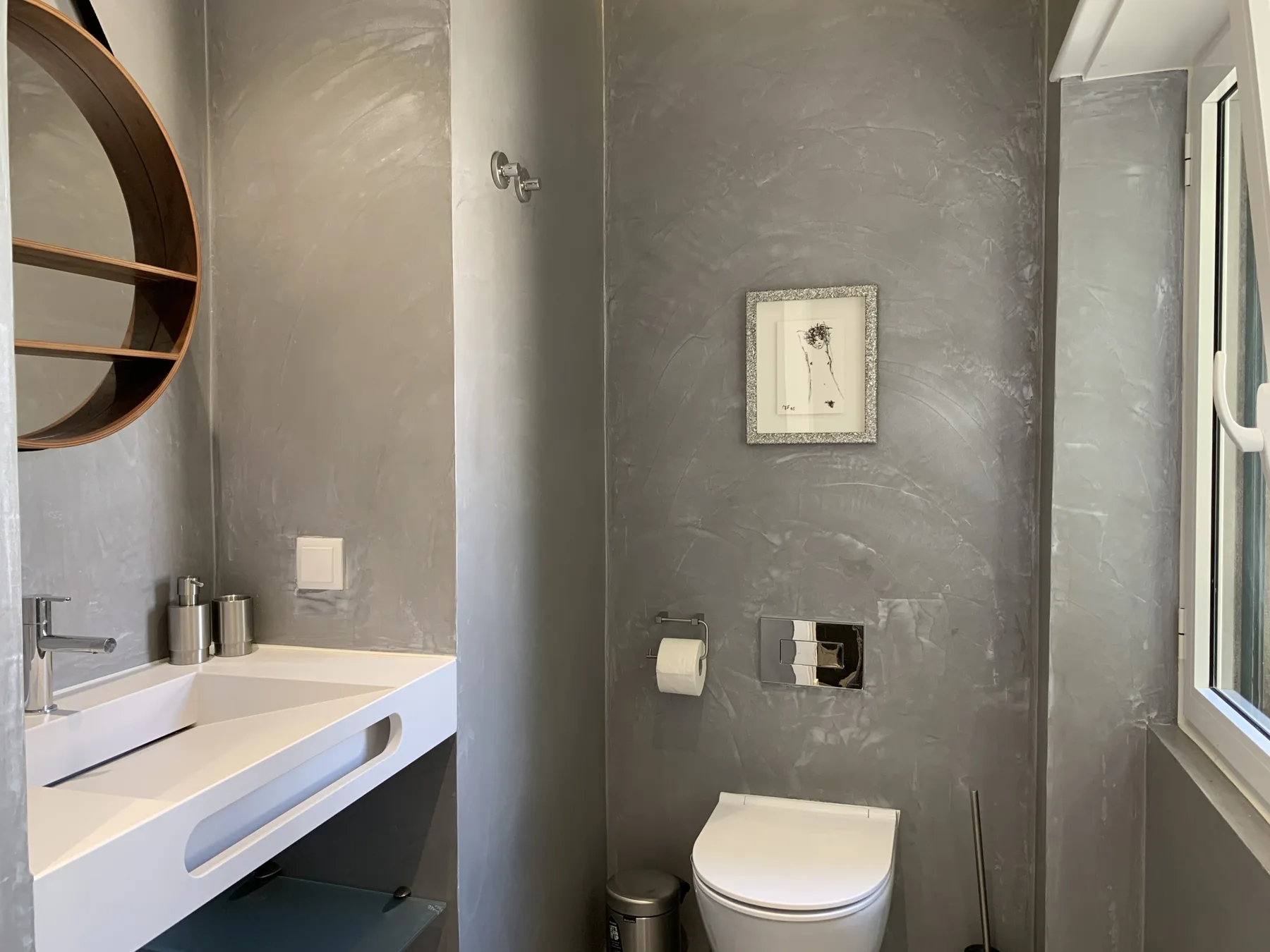 Un baño moderno con lavabo suspendido e inodoro.