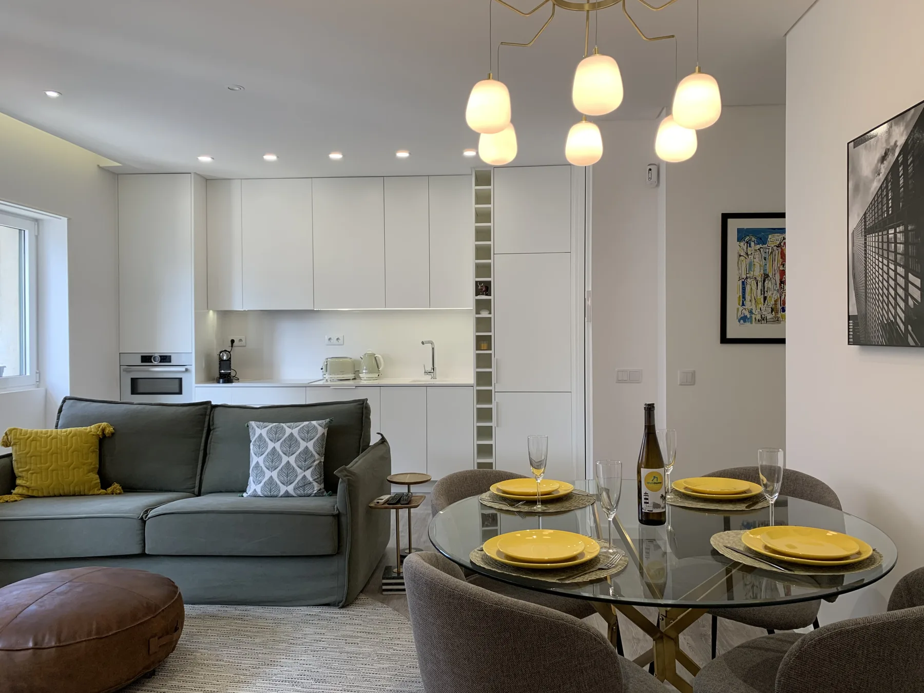 Una sala de estar y comedor de concepto abierto con un sofá gris y una mesa puesta.