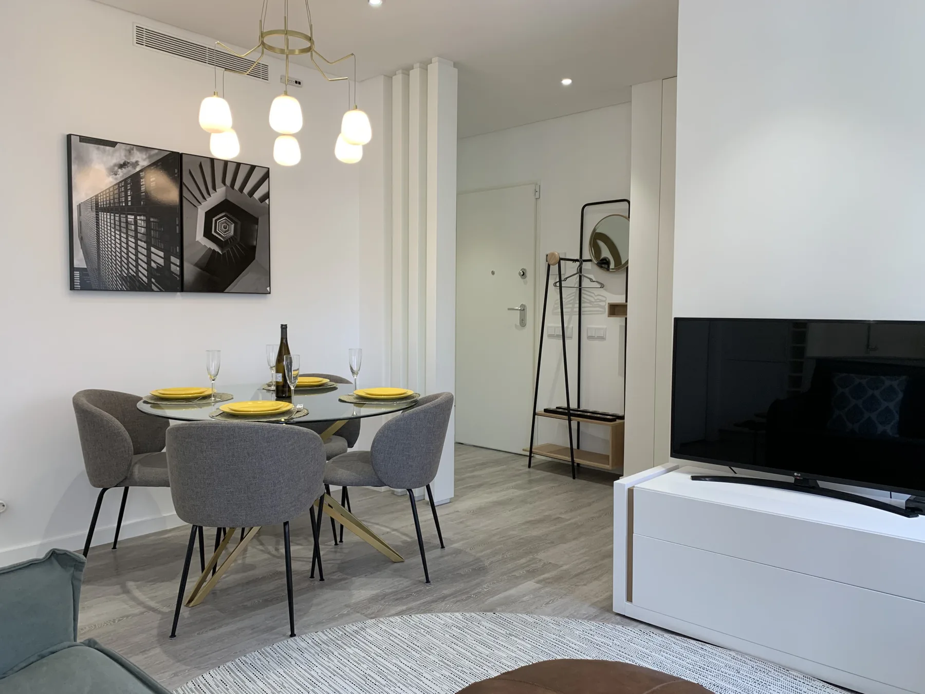 Comedor con una mesa puesta y un televisor en la sala contigua.