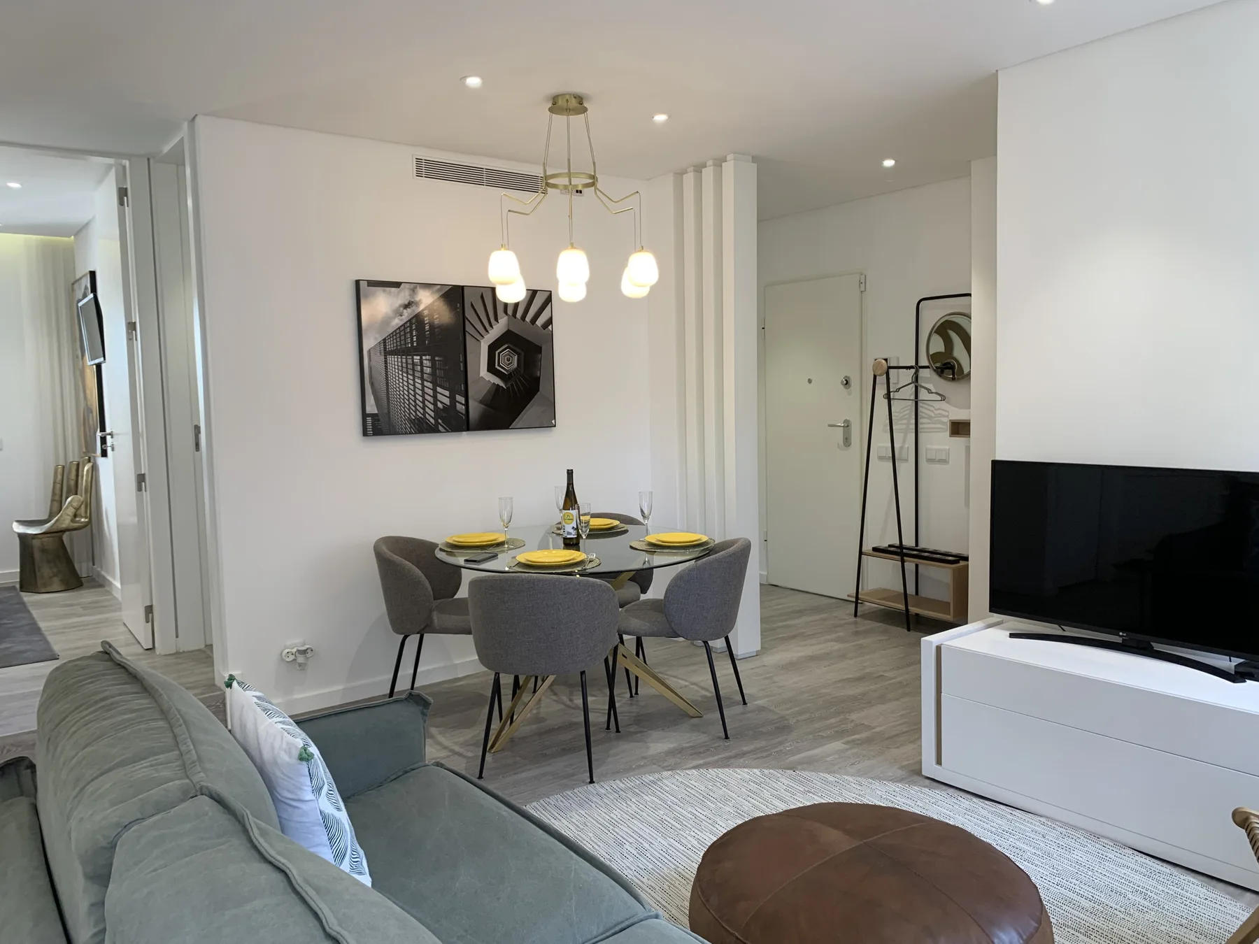 Comedor con la mesa puesta y asientos junto a una zona de estar.