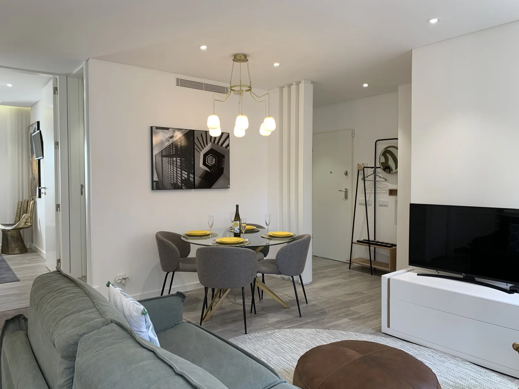 Una sala de estar y comedor con asientos alrededor de una mesa y un televisor.