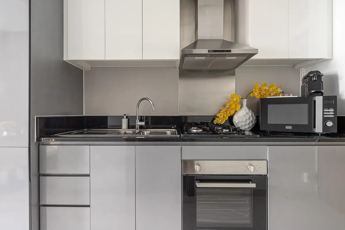 Una cocina moderna con gabinetes blancos, una encimera y electrodomésticos integrados.
