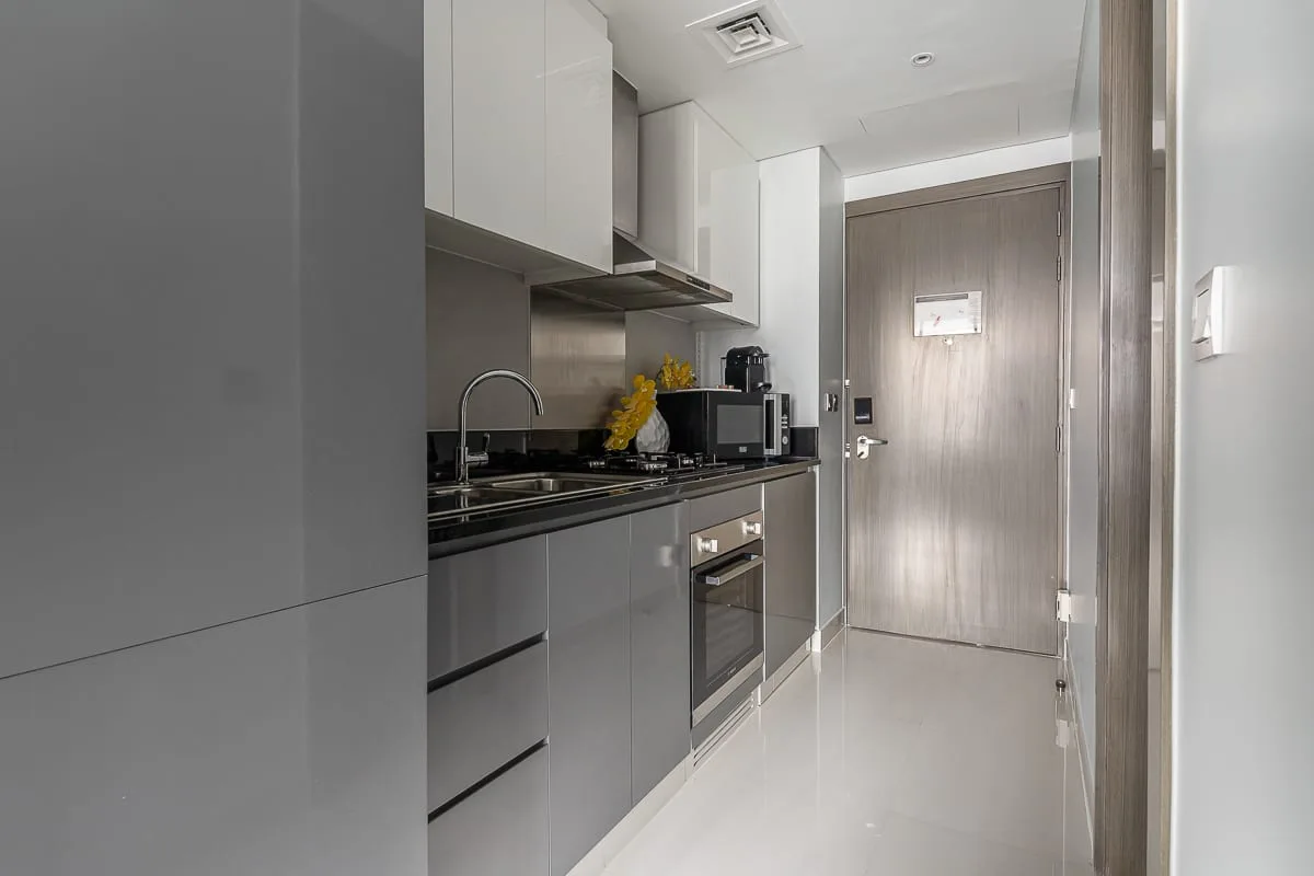 Una cocina moderna con gabinetes grises, una encimera y electrodomésticos integrados.