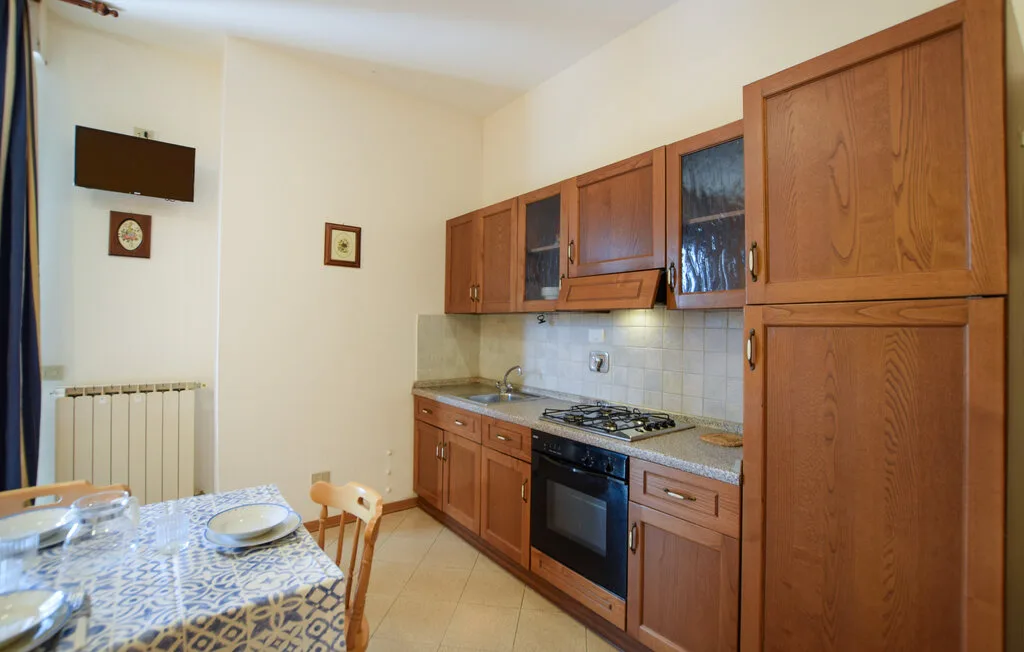 Una cocina con gabinetes de madera, una estufa y una mesa de comedor.