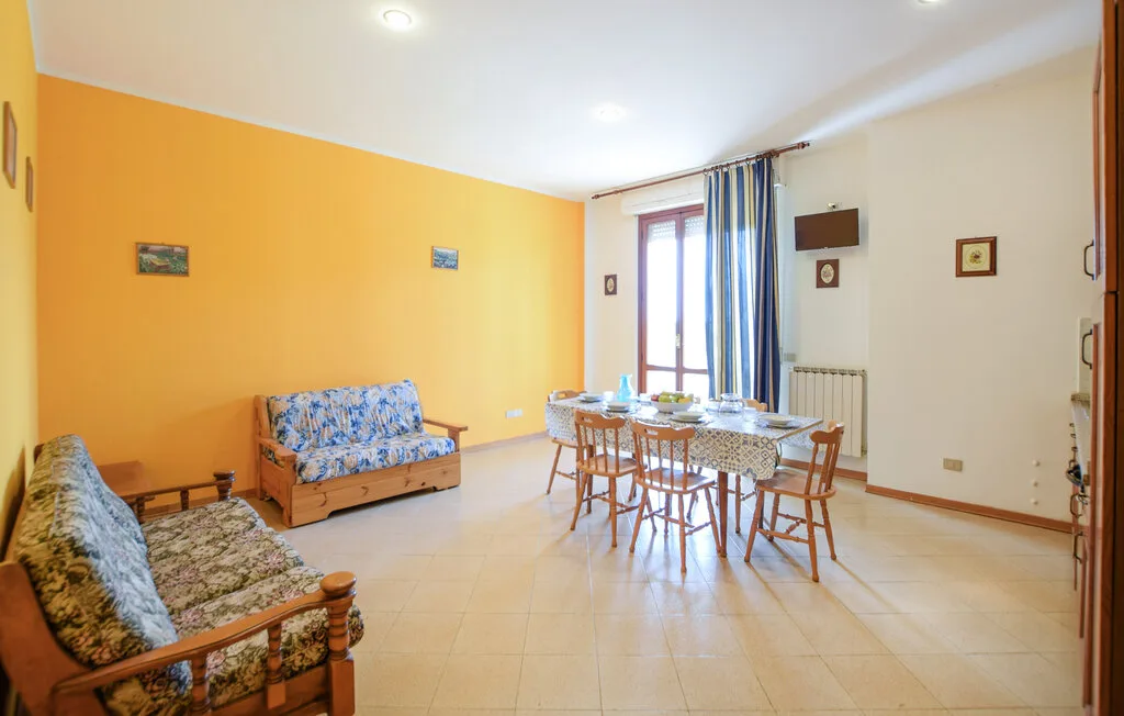 Una luminosa sala de estar y comedor con asientos y una mesa junto a la ventana.