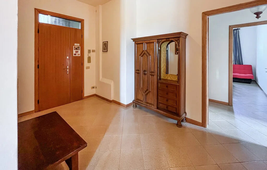 Un recibidor con una puerta de entrada de madera y un armario con espejo.