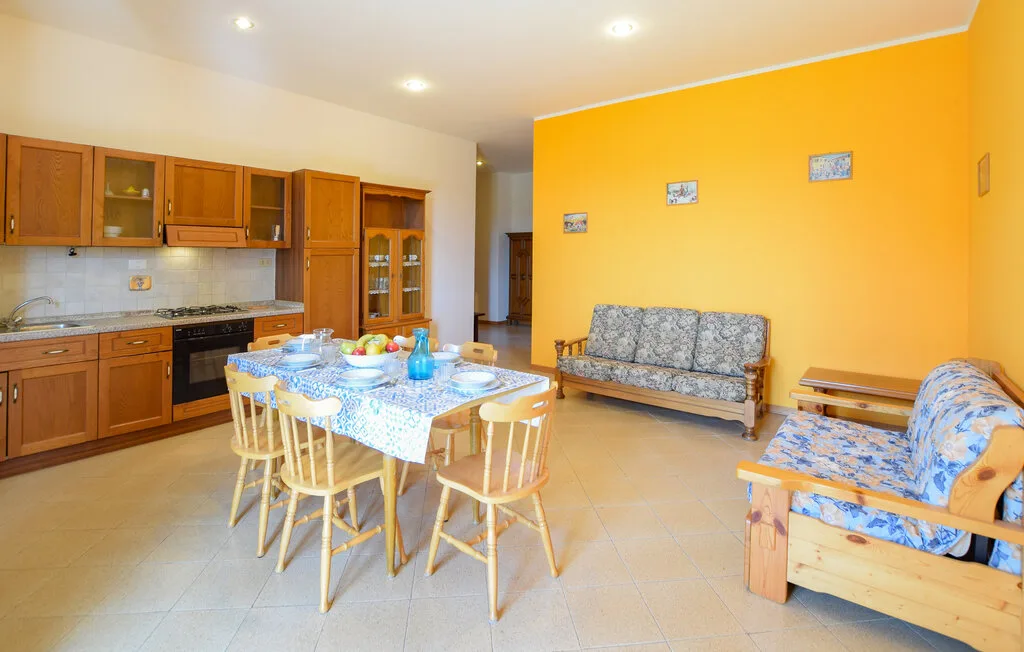 A kitchen and dining area opens into a bright sitting area with patterned seating.