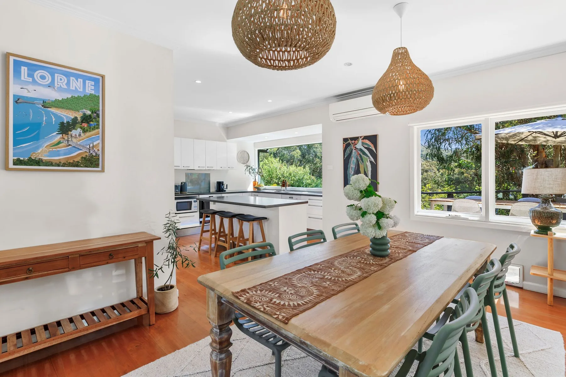 A dining area with a wooden table beside an open kitchen.