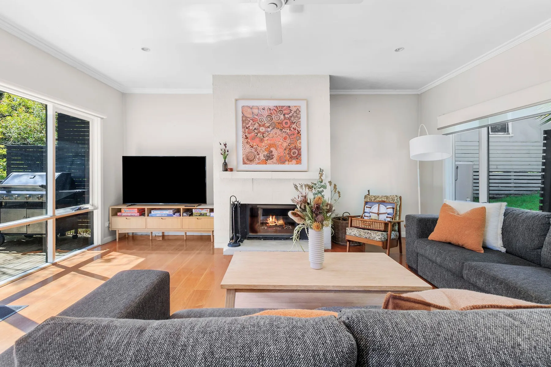 Living room with seating, a television, and a fireplace.