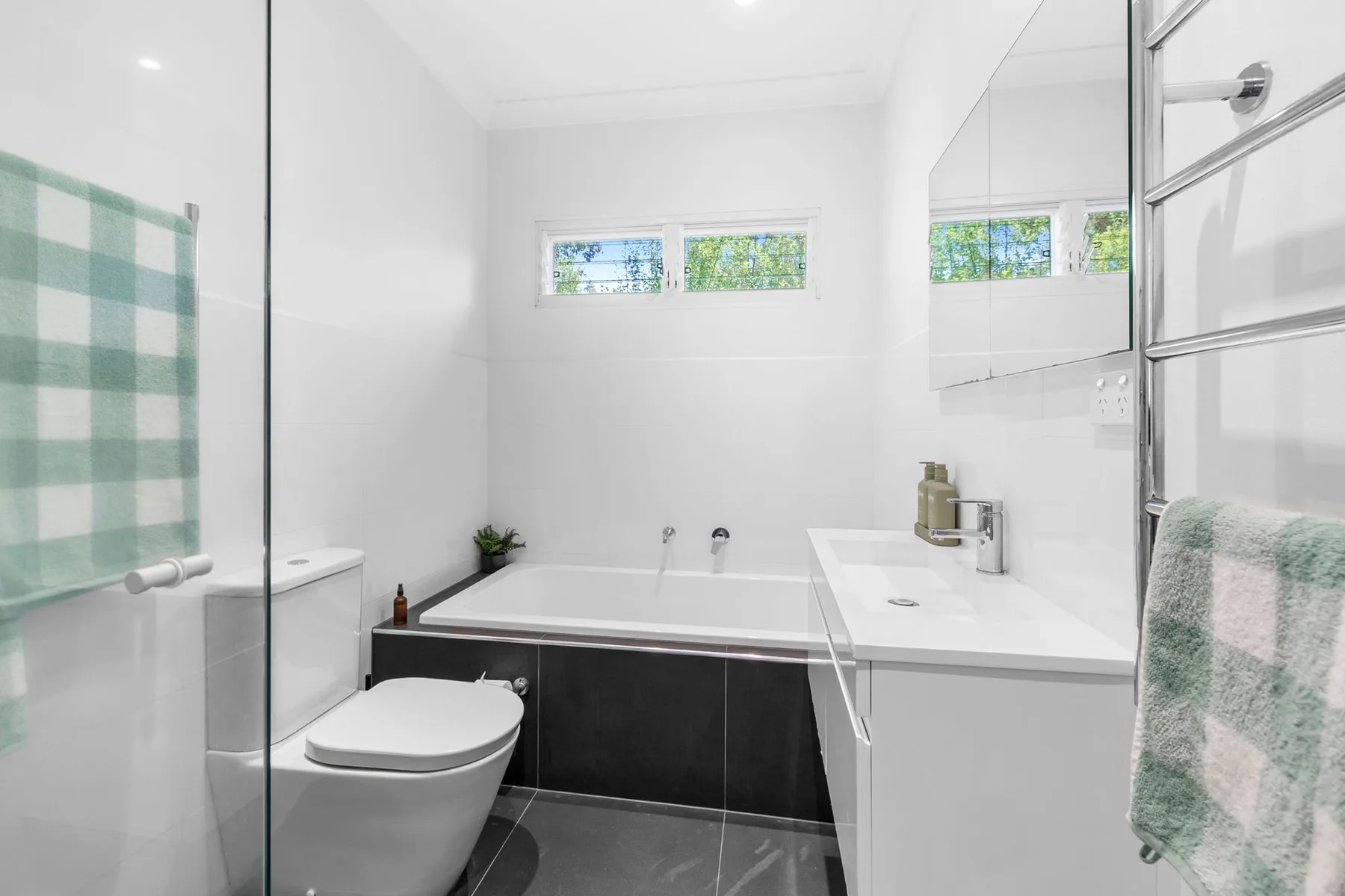 A bright bathroom with a bathtub, toilet, and sink.