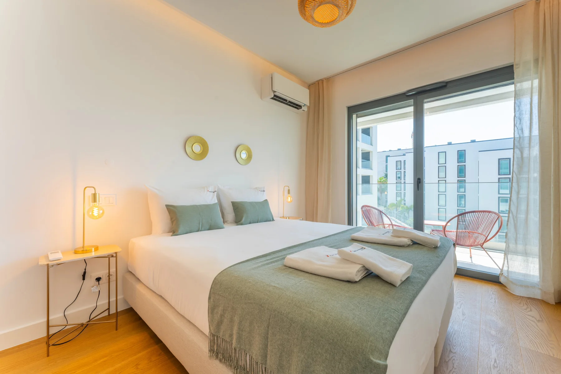 Un dormitorio con una cama grande y puertas de cristal que dan a un balcón.