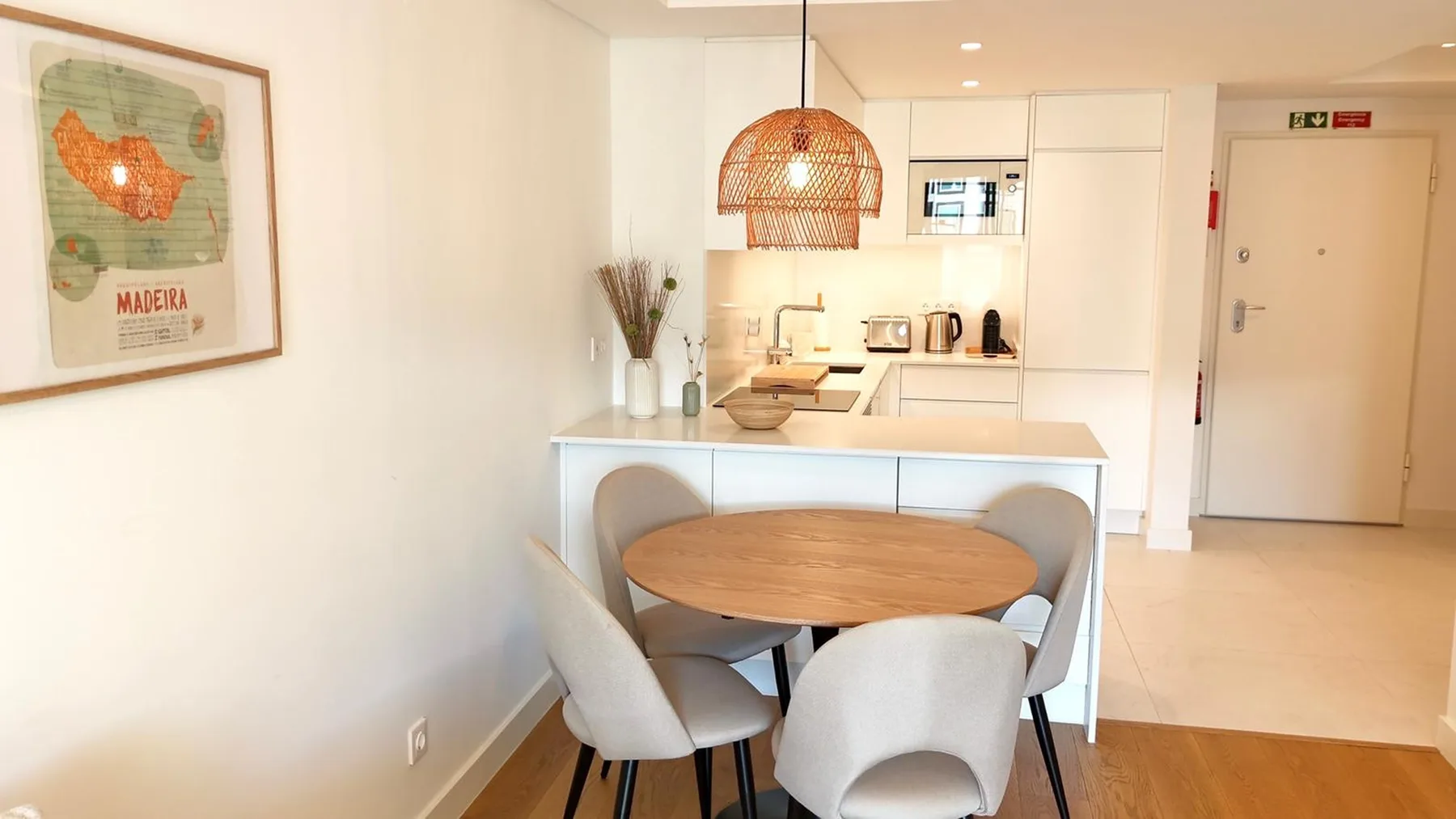 Comedor con una mesa redonda y una cocina abierta detrás.