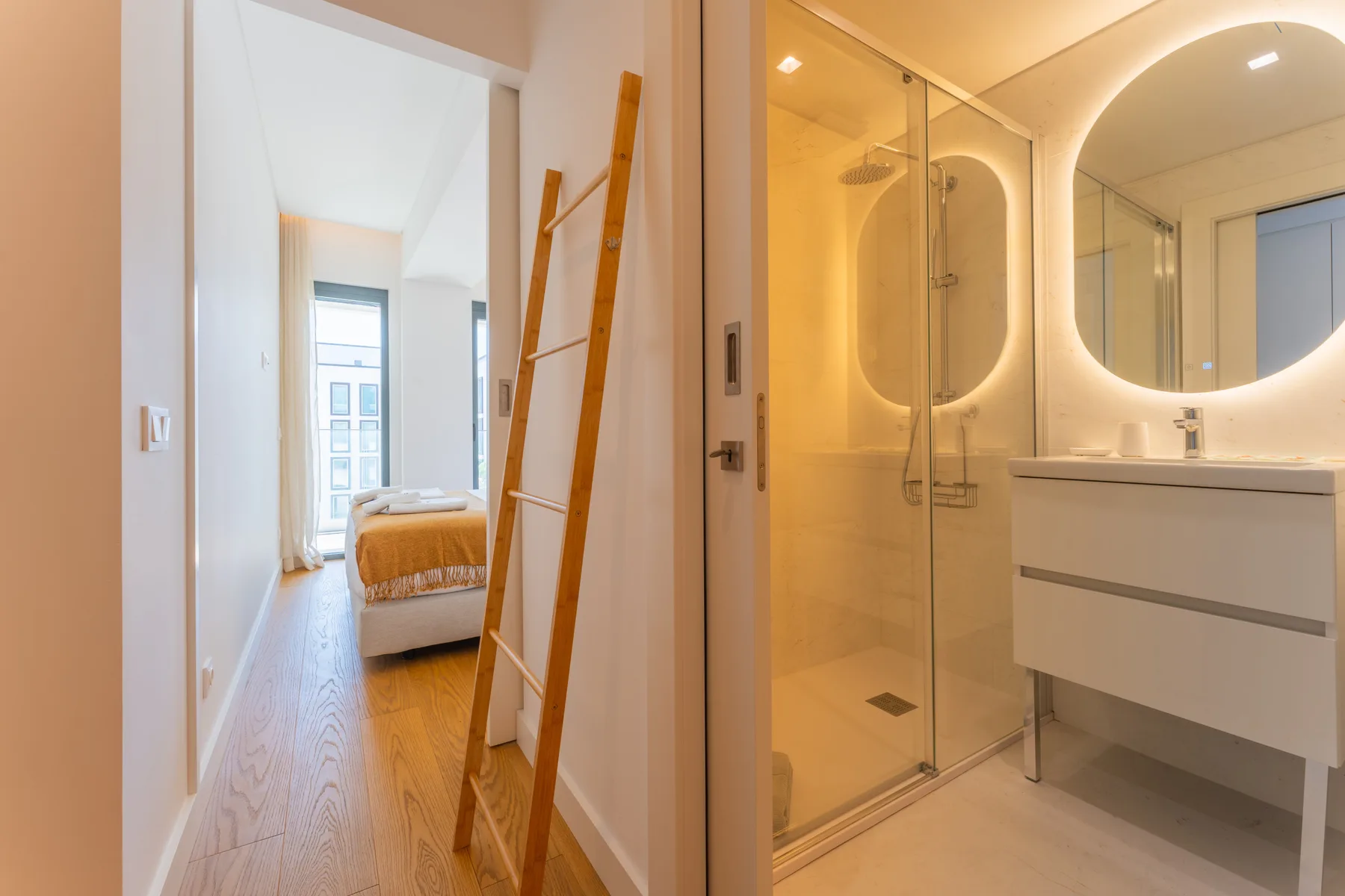 Se ven un dormitorio y un baño a través de una puerta abierta.