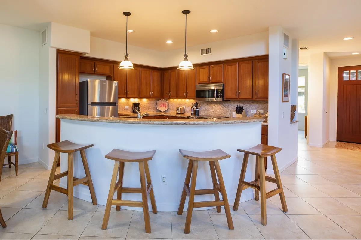 Una cocina con una barra curva y taburetes de madera.