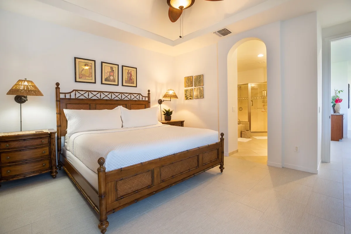 Un dormitorio con una cama de madera, mesitas de noche y una entrada arqueada.