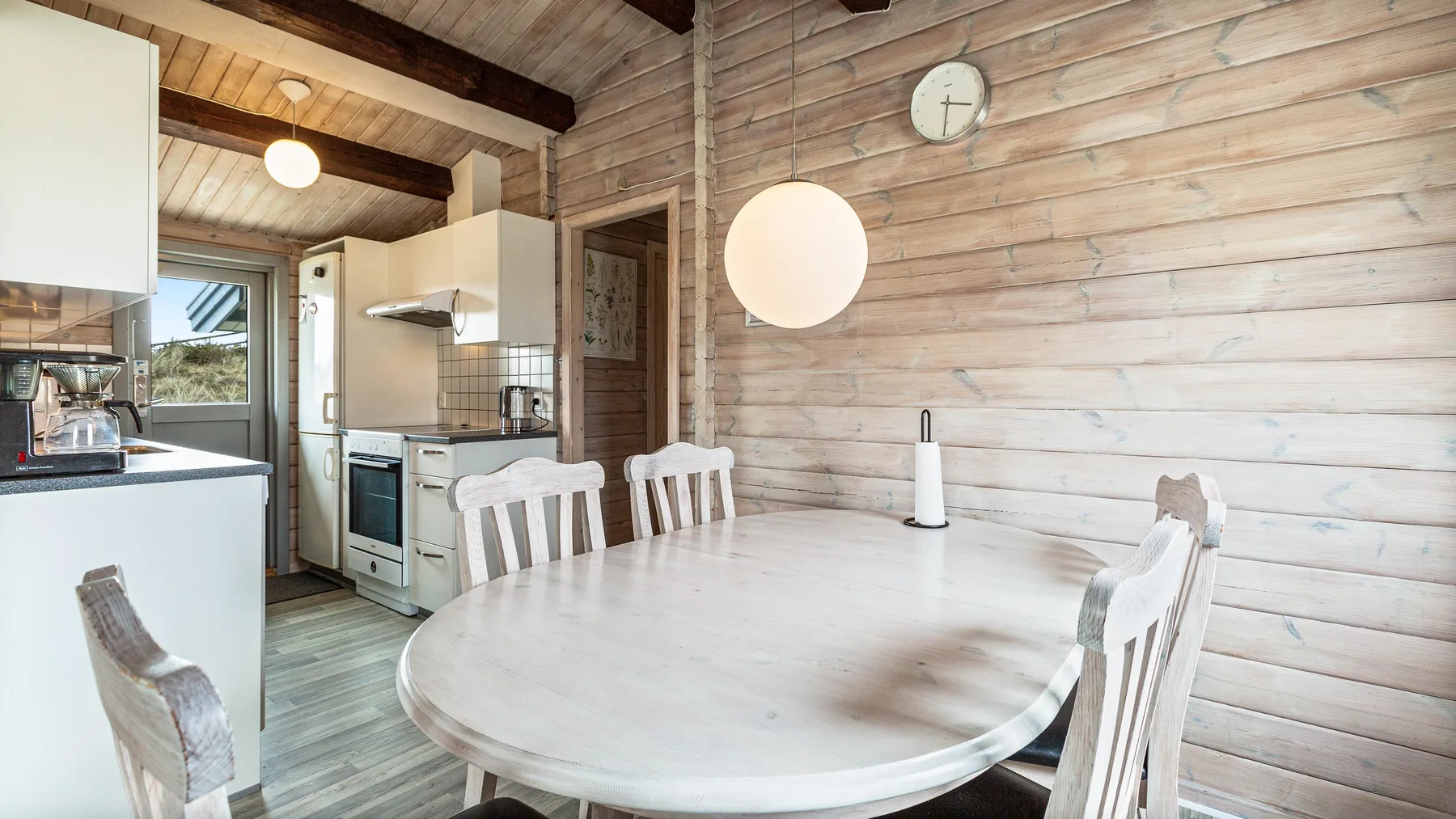 Un comedor con una mesa redonda junto a una cocina abierta.