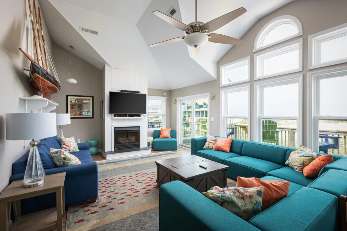 A bright living room with seating arranged around a coffee table and fireplace.