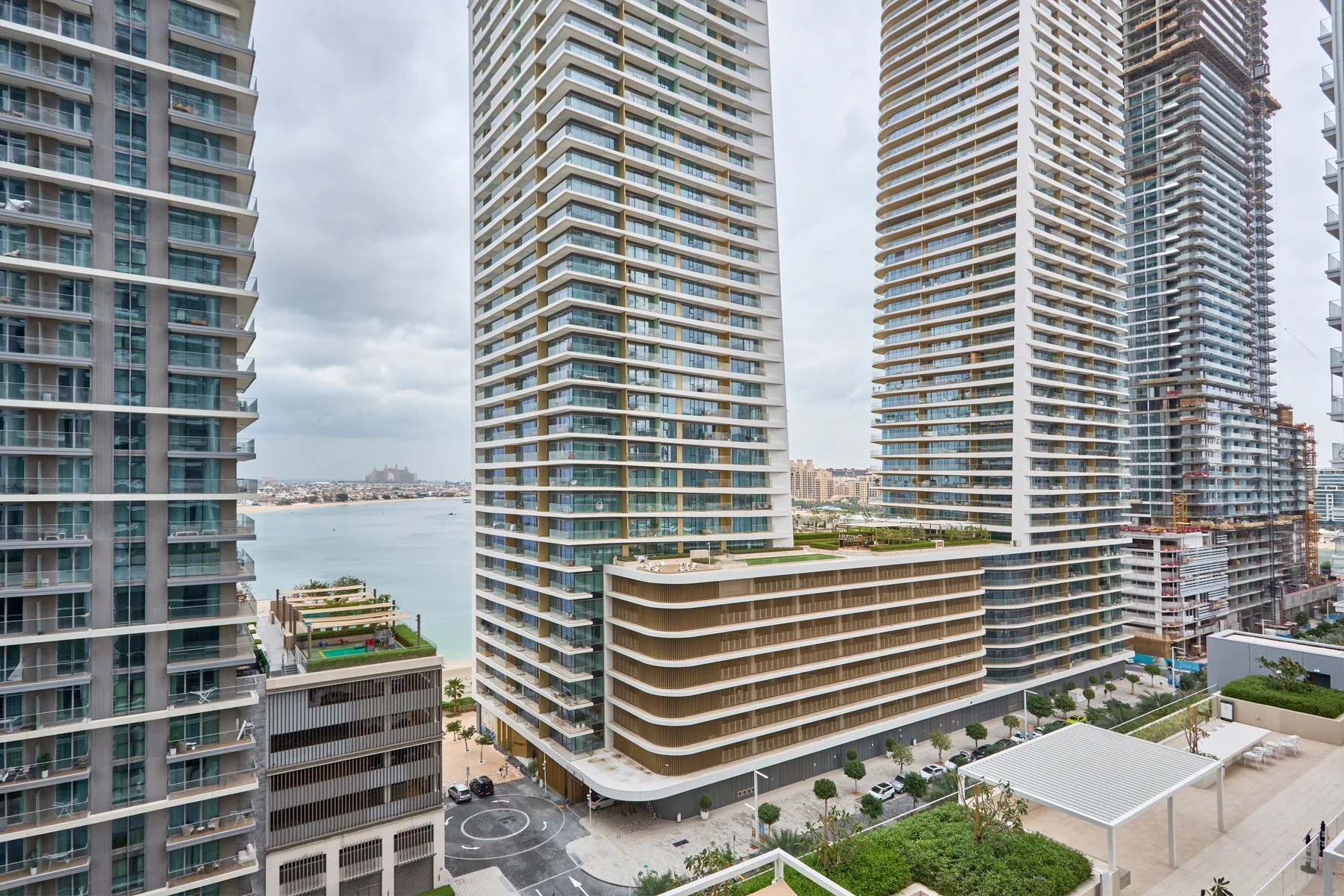 High-rise residential towers overlook a waterfront with landscaped grounds.