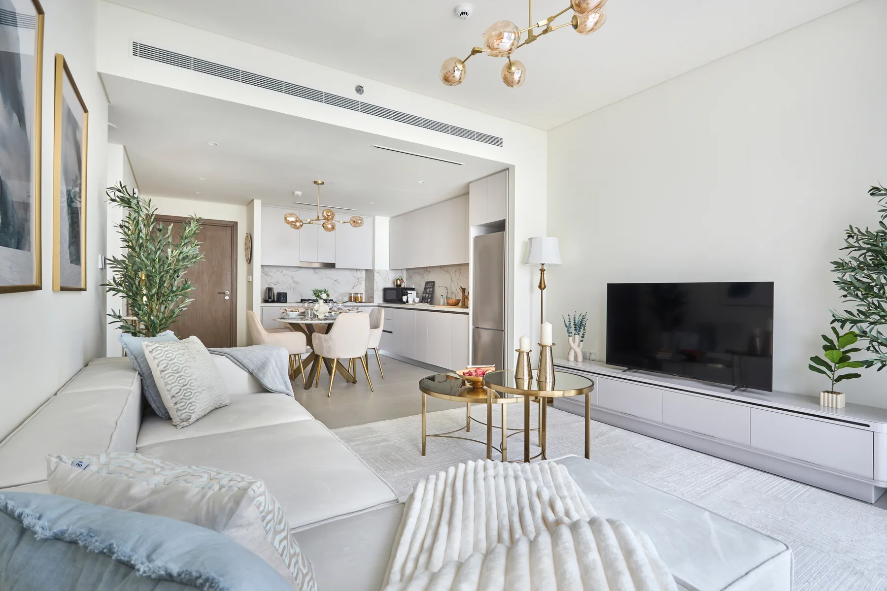 A bright living room opens onto a dining area and kitchen.