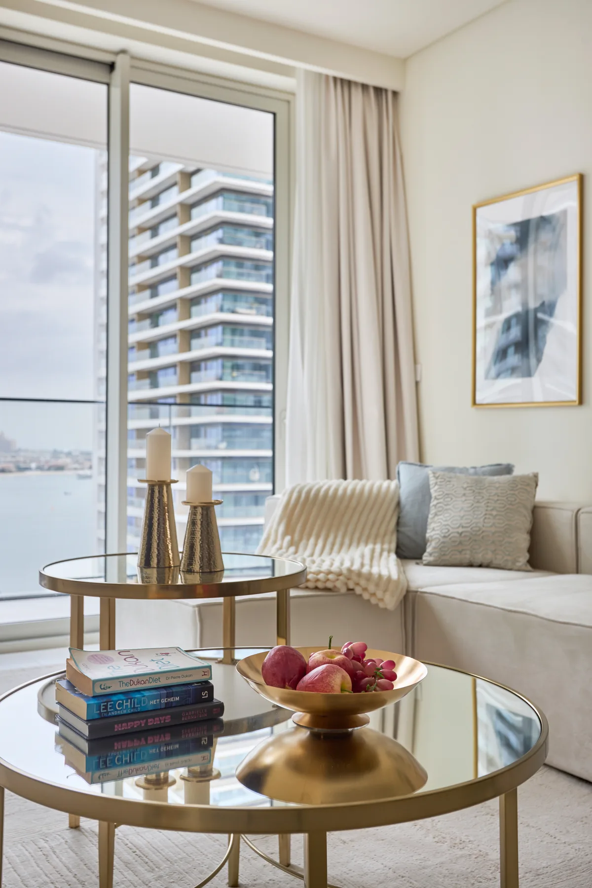 A bright living room with a seating area, round tables, and a large window.