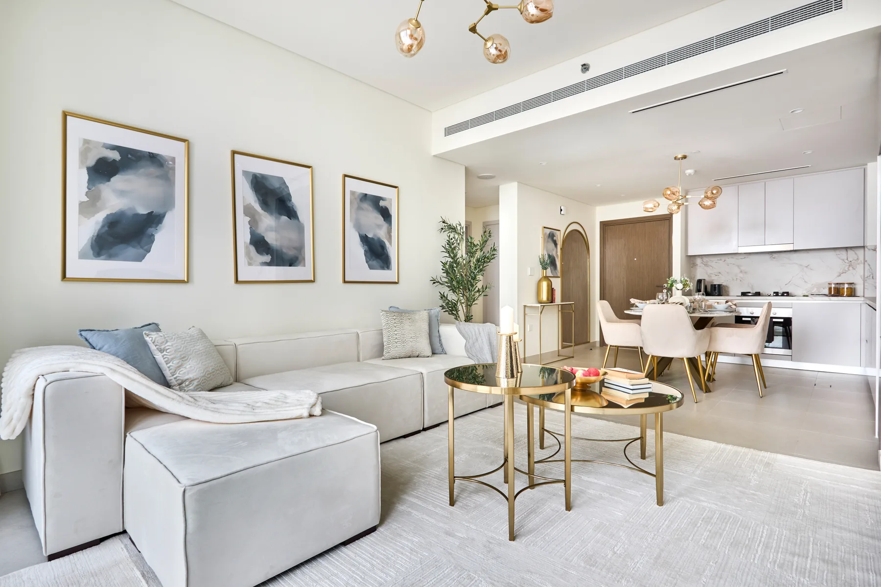 A bright living room with seating and a dining area beyond.