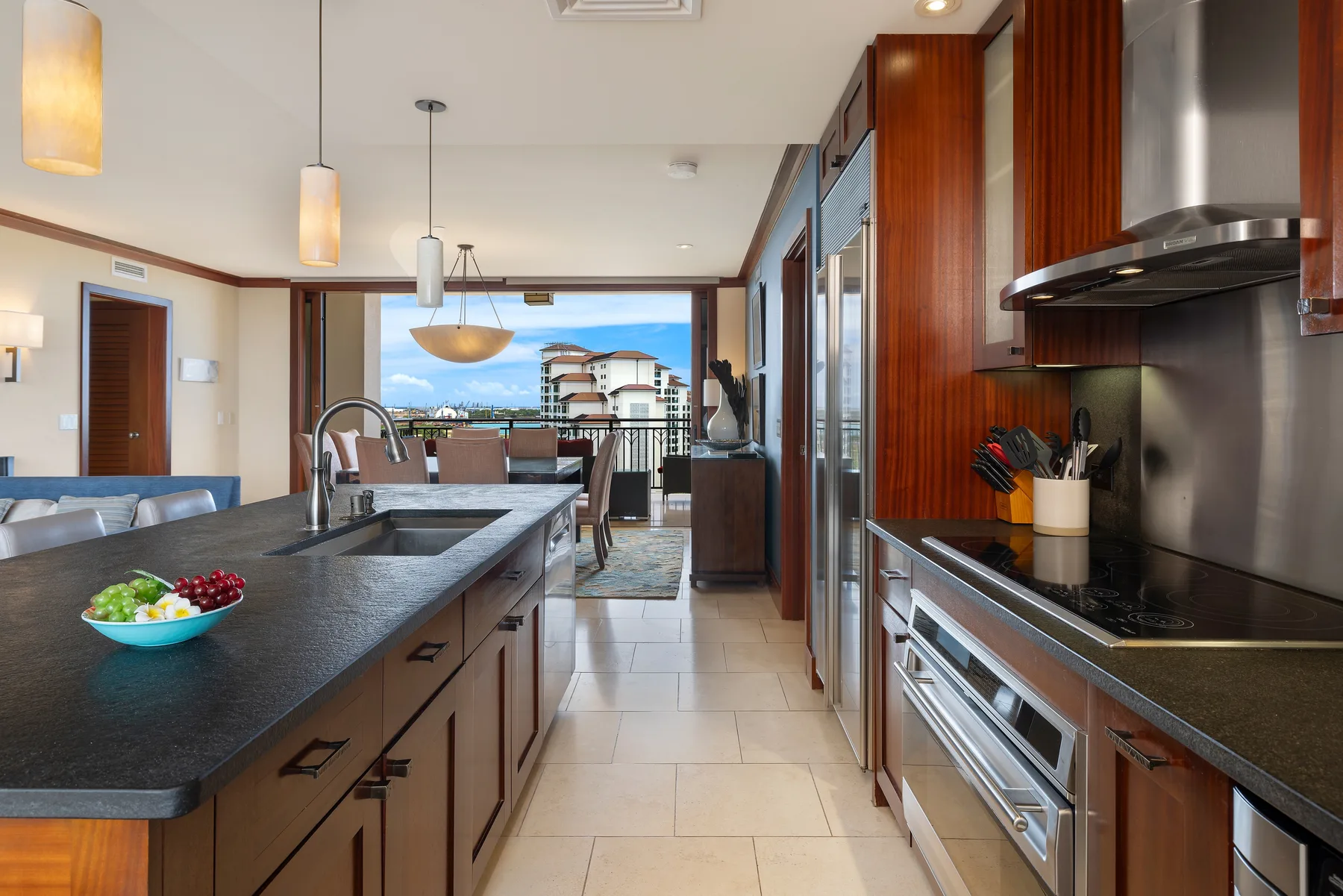 Una cocina moderna con una isla larga y un comedor al fondo.