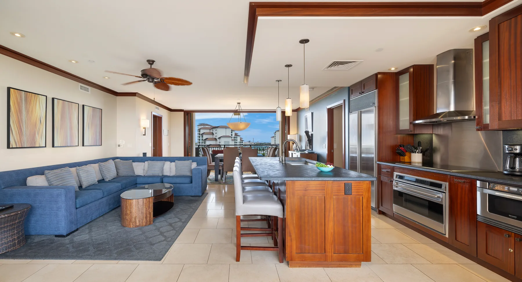 Sala de estar y cocina de planta abierta con un sofá azul y una isla central.
