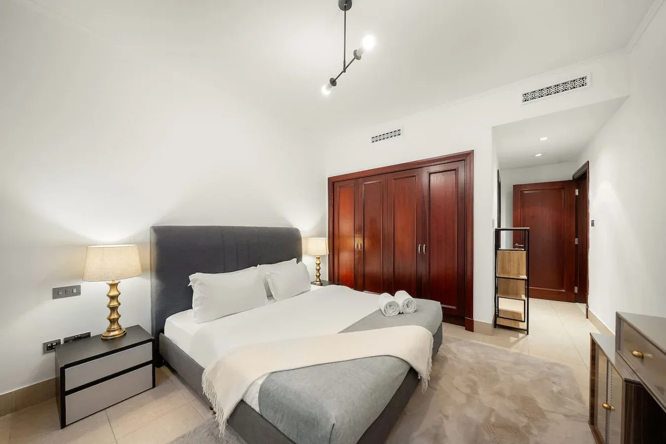 Un dormitorio con una cama bien hecha y mesas de noche.