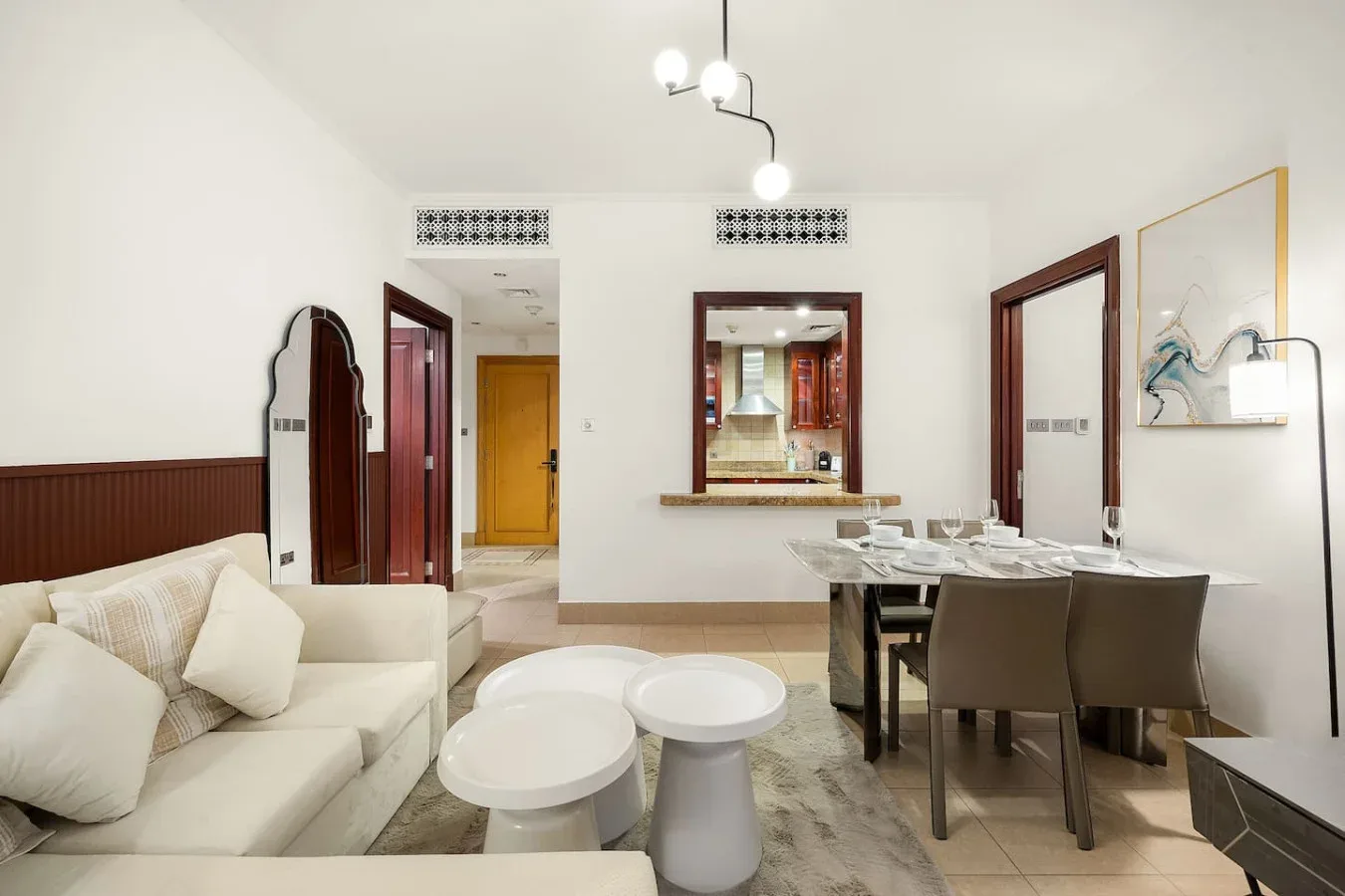 Una luminosa sala de estar y comedor con asientos blancos y una mesa.