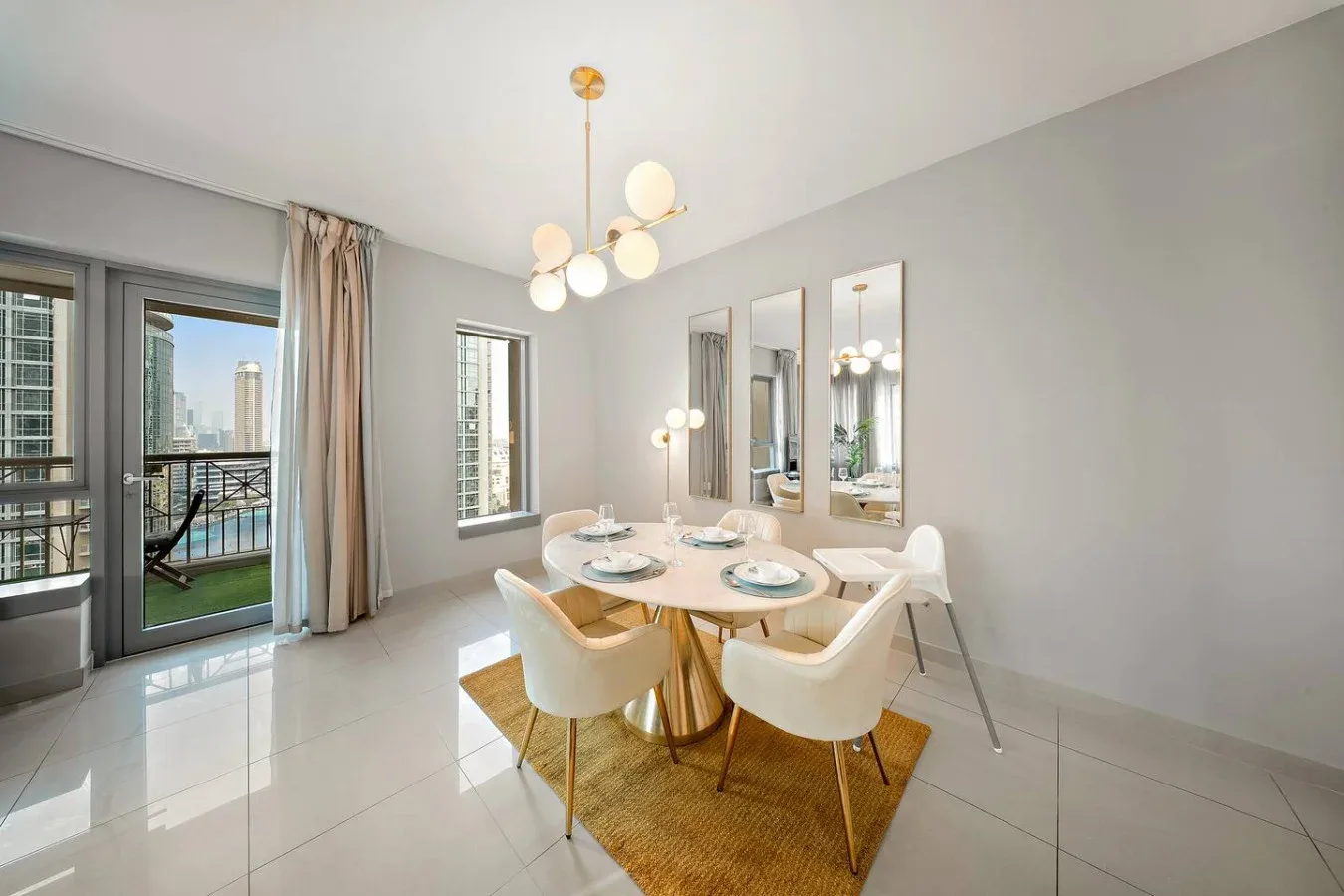 Un comedor luminoso con una mesa redonda junto a puertas de vidrio que dan a un balcón.